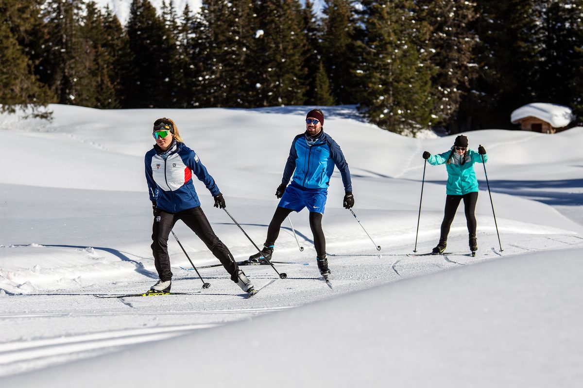 Langlauflehrer der Schneesportschule Arosa übt mit zwei Gästen die Skating-Technik auf einer frisch gewalzten Loipe