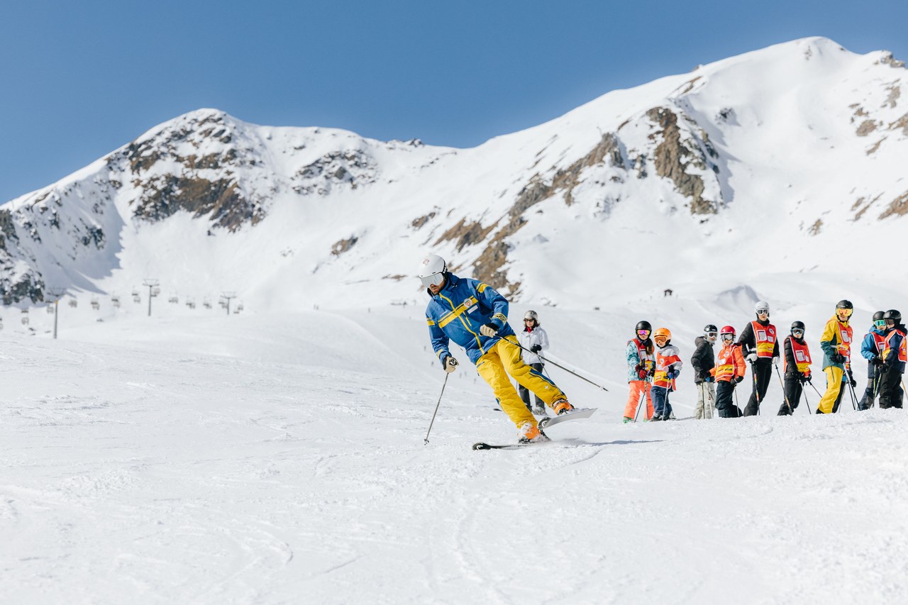 Schneesportlehrer der Skischule Arosa fährt einer Red-Star-Gruppe auf der Piste voraus